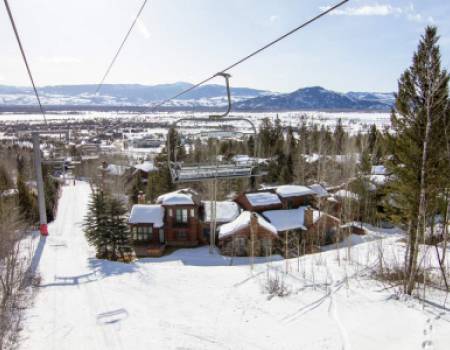 Housing in snow with chairlifts in front