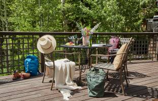 Granite Ridge deck with chairs, backpack, hats, flowers in a vase on the table